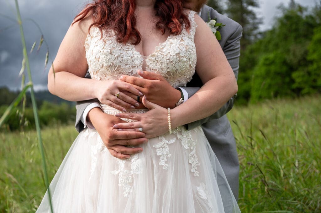close up of bride and groom hands with rings